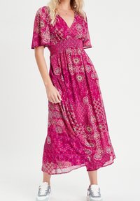 Maxi kjole i et levende pink stof, med v-hals, korte flæseærmer, smocked bodice og blomster mønstre over det hele.
