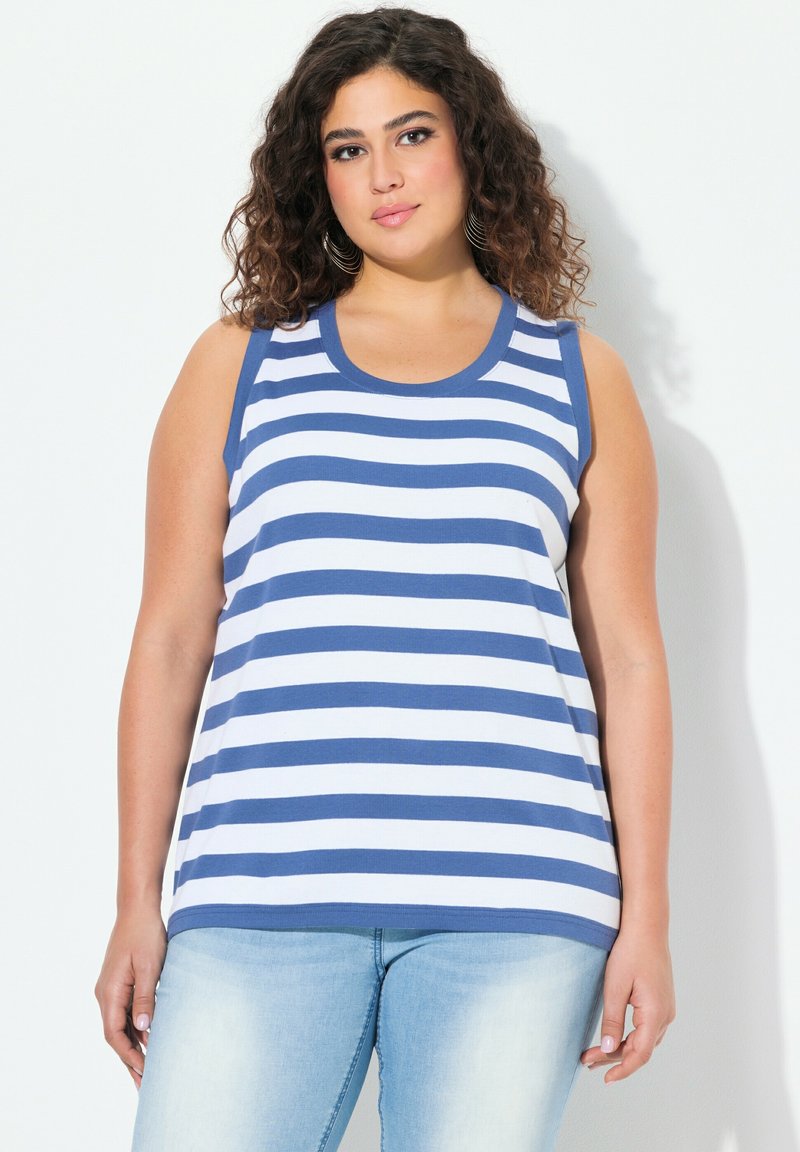 Top senza maniche a righe blu e bianche con scollatura tonda, realizzato in tessuto morbido, abbinato a jeans azzurri chiari. Tessuto liscio, vestibilità rilassata.