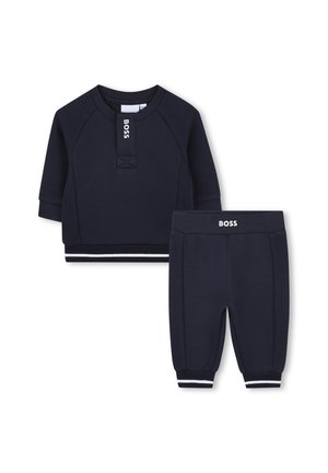 Ensemble de survêtement pour enfants bleu marine comprenant un haut à manches courtes avec texture côtelée et un pantalon assorti avec des poignets élastiques et des accents blancs.