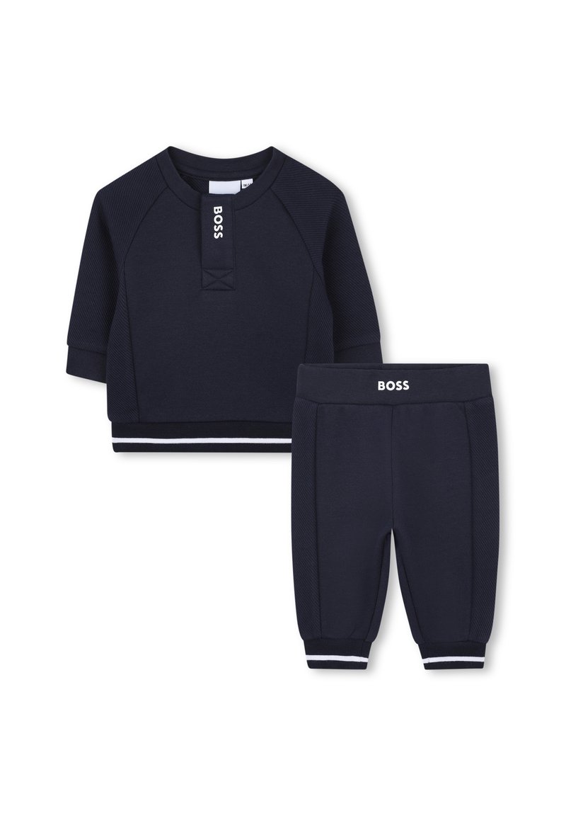 Navyblauwe kindertrainingsset bestaande uit een korteblend shirt met geribbelde textuur en bijpassende broek met elastische boorden en witte accenten.