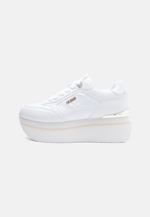 Białe sneakersy na platformie z markowym bocznym detalem, sznurowanym zapięciem i metalicznym akcentem na pięcie.