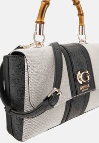 Sac structuré avec un corps en maille beige, des accents en cuir noir, une poignée en bambou et un détail en logo doré.