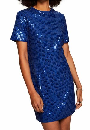 Woman wearing a short-sleeve, above-knee royal blue sequin dress with a round neckline and textured pattern.