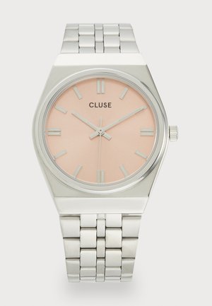 Montre en acier inoxydable argenté avec un cadran rose, comprenant des index horaires rectangulaires et une surface texturée. Boîtier rond avec une lunette lisse.