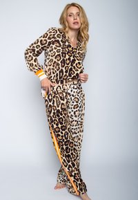 Leopardprint pyjama set met een lange mouwen top met oranje gestreepte manchetten en bijpassende broek met een contrasterend patroon. Zachte textuur.