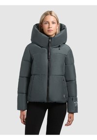 Grå pufferjakke med en stor hætte, lynlåsforbindelse og sidelommer. Har en tekstureret finish og branddetalje på ærmet.