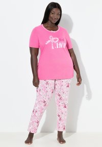 Růžový top s krátkým rukávem a bílým lemováním má grafiku "Think PINK". Odpovídající růžové pyžamové kalhoty zobrazují rozptýlené vzory nůžek. Bavlněný materiál.