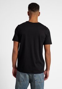 Hummel GRAPHIC DISPLACED LOGO TEE - Camiseta estampada - black
