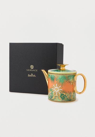 Τσαγιέρα με χρυσή λαβή και ρουξούνι, διακοσμημένη με πράσινα φοινικοειδή φύλλα και πορτοκαλί φόντο, δίπλα σε μαύρο κουτί με την επωνυμία Versace Rosenthal.