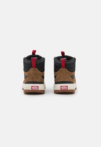 Sneakers altas em suede castanho e sintético preto com detalhes em vermelho e sola branca. Apresentam um colarinho acolchoado e uma alça para facilitar o calçar.
