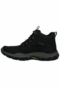 Botas negras de media caña repelentes al agua, con una parte superior de ante texturizado, ojetes reforzados y una suela dura de goma con el logo "Goodyear".