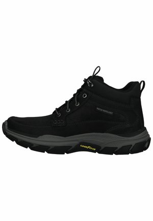 Botas negras de media caña repelentes al agua, con una parte superior de ante texturizado, ojetes reforzados y una suela dura de goma con el logo "Goodyear".