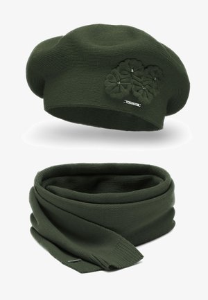 Béret en tricot vert avec applique florale et détail en métal, accompagné d'une écharpe verte assortie, affichant une texture douce et des bords lisses.
