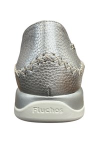 Zilveren leren schoen met een gestructureerde oppervlakte, lichte stiksels op de bovenkant en een grijze rubberen zool met de merknaam "Fluchos" in reliëf.