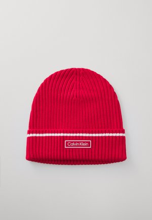 Rode gebreide beanie met geribbelde textuur, voorzien van een witte streep en een rechthoekig Calvin Klein-logo patch op de voorkant.