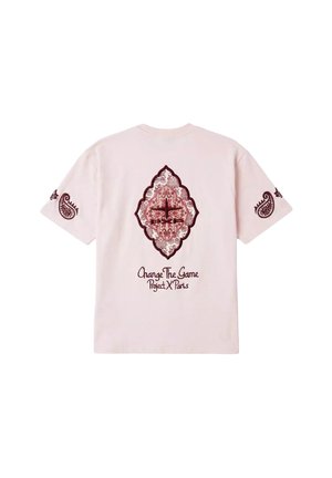Camiseta rosa claro con diseños paisley burdeos en las mangas y un patrón central ornamentado en forma de diamante, además del texto "Change The Game Project X Paris".