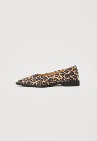 Zapato plano de punta afilada con un patrón de estampado de leopardo en beige y negro, que presenta un bajo tacón negro y una textura suave.