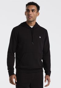 Zwarte hoodie gemaakt van zachte stof, met een voorzak, geribde manchetten en een klein logo op de borst. Eenvoudig ontwerp en comfortabele pasvorm.