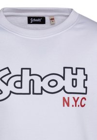 Felpa bianca con scollo rotondo. Presenta un grande logo nero "Schott" e il testo rosso "N.Y.C." sul davanti. Materiale in cotone.