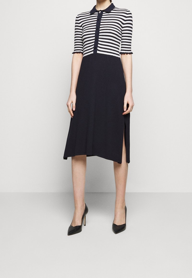 Abito a righe navy e bianche con collo polo, maniche corte, chiusura frontale con bottoni e spacchi laterali, realizzato in una maglia testurizzata.