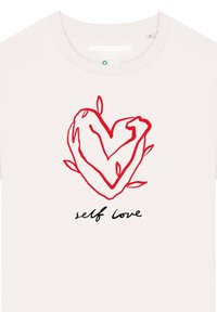 Weißes Baumwoll-T-Shirt mit einem handgezeichneten roten Herz, umgeben von Blättern, und dem Spruch "Selbstliebe" in schwarzer Schreibschrift.