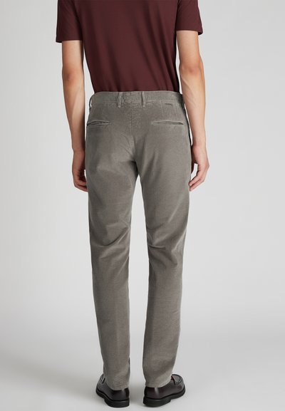 Pantaloni in corduroy grigi con una texture a coste verticali, tasche posteriori e una vestibilità slim, abbinati a una camicia a maniche corte color bordeaux.