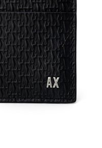 Black leather cardholder featuring embossed "AX" pattern and silver-tone hardware. Smooth texture with clean edges and stitched detailing.