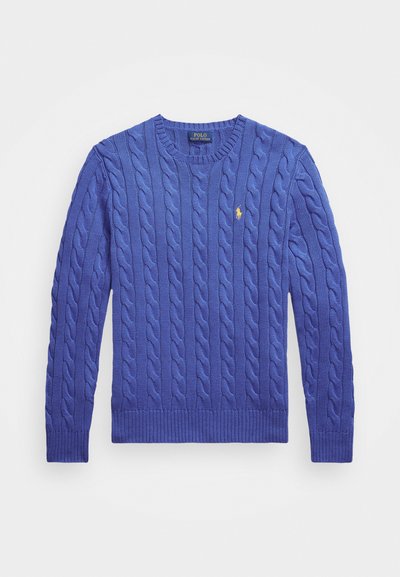 Tīkla adījuma džemperis ķēniša zilā krāsā, ar apaļu kakla izgriezumu, ribotām aprocēm un apakšmalu, kā arī mazu izšūtu logotipu uz krūšu.