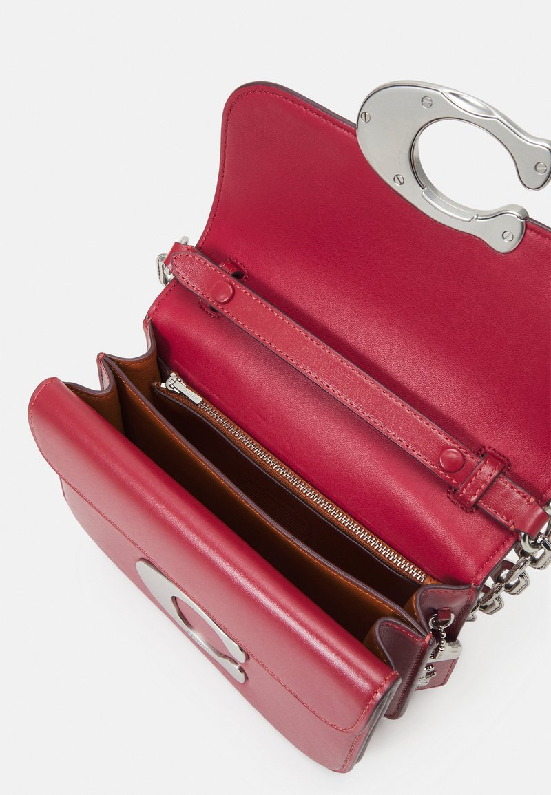 Rote Leder-Schultertasche mit einem silbernen Verschluss. Verfügt über eine glatte Textur, Innenfächer und eine Reißverschluss-Tasche.
