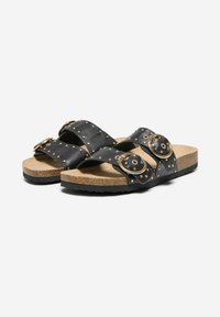 Sandali neri con due ampie cinghie dotate di hardware circolare dorato e accenti di borchie. Soletta in sughero con suola in gomma nera testurizzata.