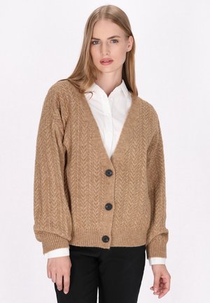 Béžový pletený cardigan s výstřihem do V, který má texturovaný vzor, dlouhé rukávy a pět černých knoflíků vpředu.