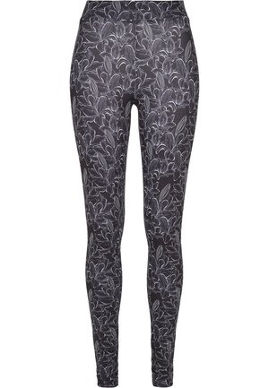 Black leggings featuring a white floral pattern. The design includes detailed botanical illustrations and a fitted silhouette. Stretch fabric.
