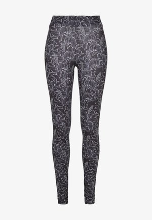 Mustat leggingsit, joissa on valkoinen kukkakuosi. Suunnittelussa on yksityiskohtaisia kasvitieteellisiä kuvastoja ja tiukka siluetti. Venymäkangasta.