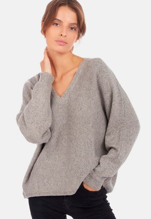Grauer, übergroßer V-Ausschnitt-Pullover aus weichem Strickstoff. Verfügt über lange, leicht gepuffte Ärmel und eine lockere Passform mit gerippten Bündchen.