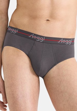 Mannelijke torso met donkergrijze slip met een gebreide tailleband waarop het merk "sloggi" staat in lichtgrijze en rode letters.