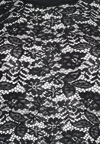 Tessuto in pizzo nero con motivi floreali, caratterizzato da disegni intricati e texture varie, che creano un aspetto dettagliato e a trama aperta.