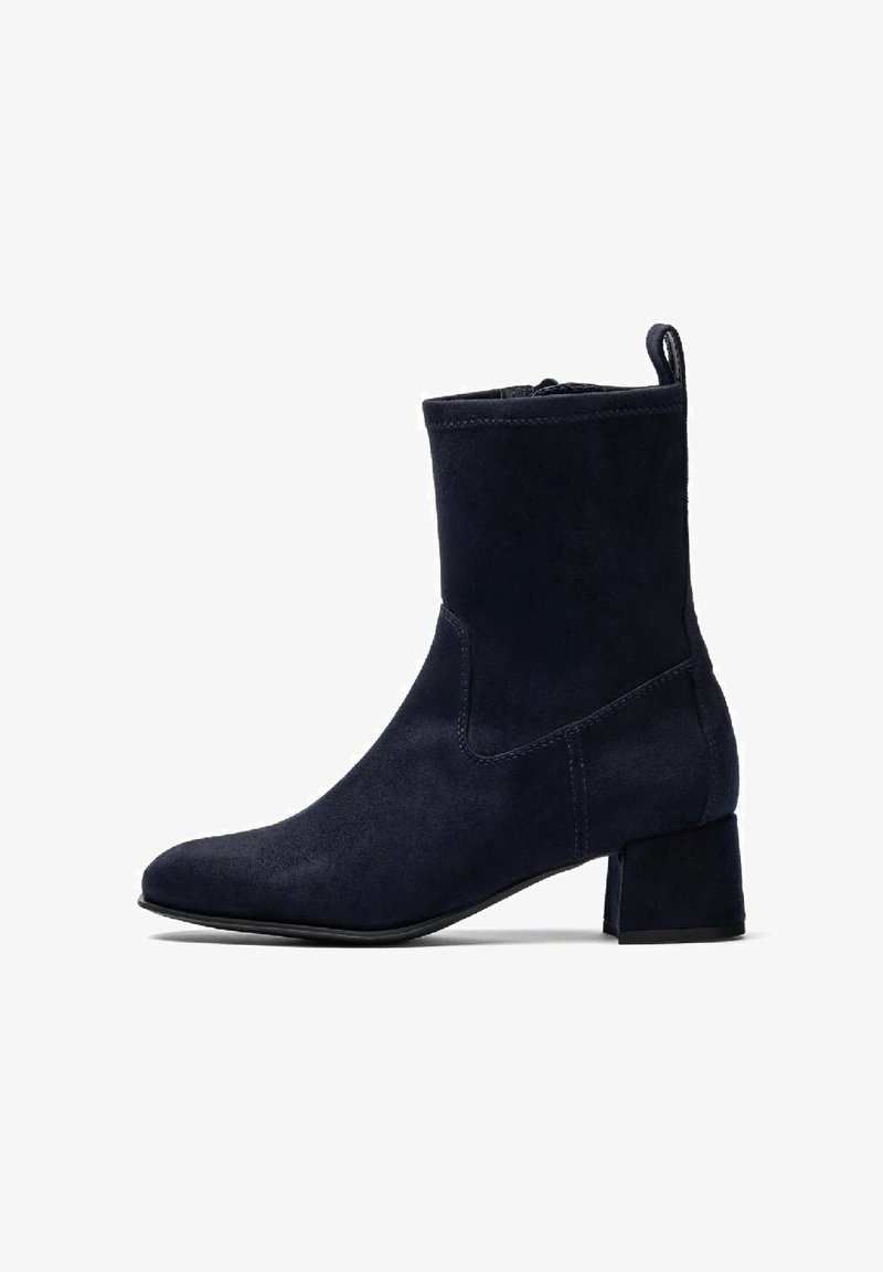 Stivaletti alla caviglia in suede blu navy con punta affusolata, gambale corto e tacco a blocco. Presentano cuciture minime e una linguetta sul retro.