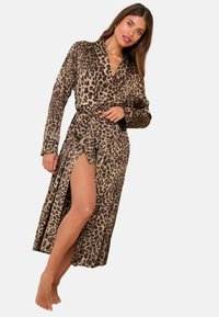Leopardmönstrad satinbelagd morgonrock med omslagdesign, långa ärmar och knytbälte. Har en hög slits på kjolen. Jordnära färger och en slät textur.
