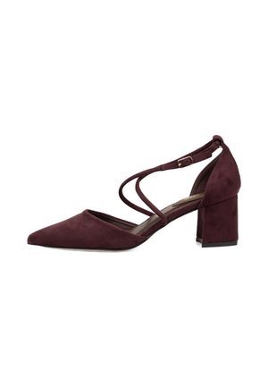 Zapato de tacón para mujer en ante morado oscuro con puntera puntiaguda, tacón grueso y doble correa cruzada en el tobillo con hebilla pequeña.