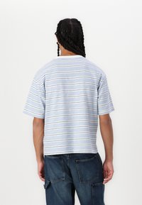 T-shirt à manches courtes, rayé en bleu clair avec des lignes bleu marine et blanches ; coupe décontractée ; en coton ; col rond ; dos uni.