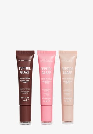 Trois tubes de sérum teinté pour les lèvres Revolution Peptide Glaze dans les teintes Pâte de Noisette, Fraises & Crème, et Guimauve Grillée.
