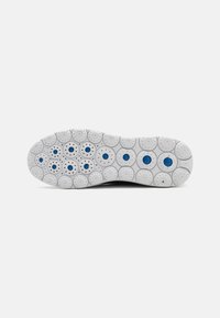 Sula av skinn i vitt gummi med cirkulära mönster och blå accenter. Texturerad yta med upphöjda prickar för grepp och flexibilitet.
