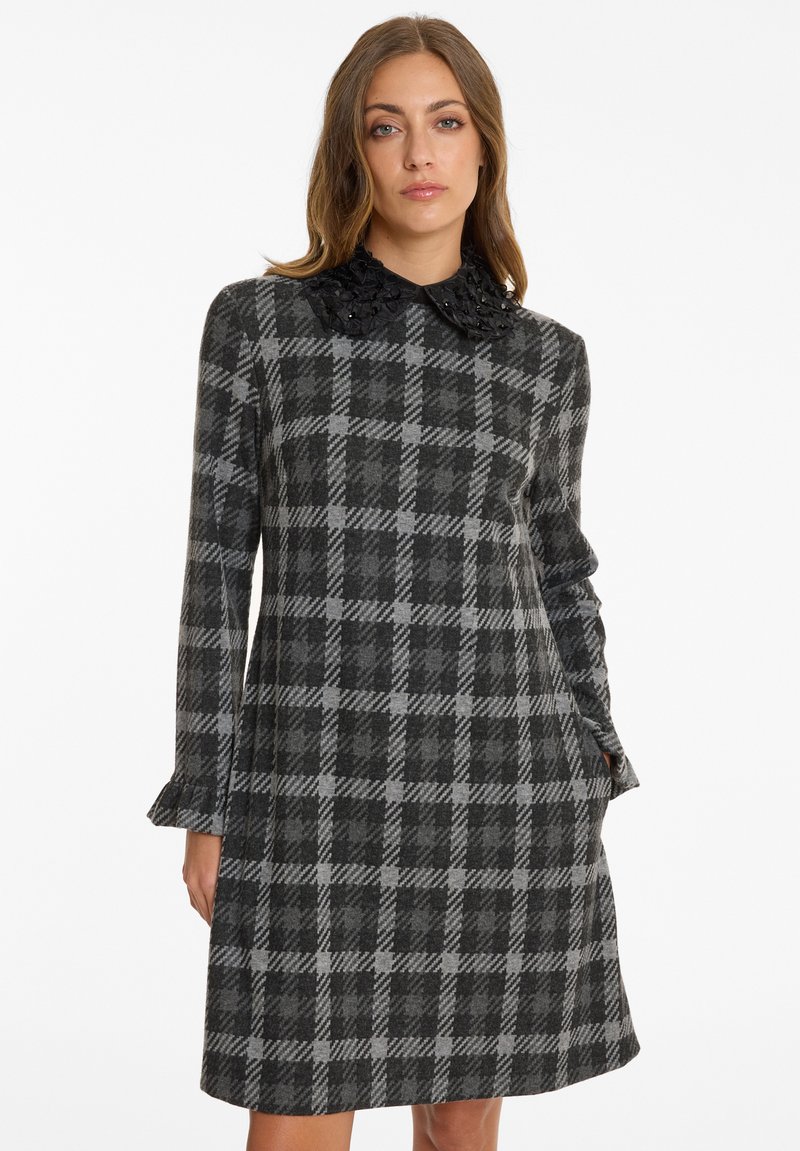 Gray checkered dress with a textured black beaded collar, long sleeves, and a flared hemline, made from a soft fabric.