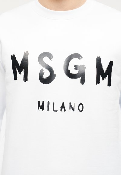 Άσπρο φούτερ με έντονα γράμματα σε στυλ πινελιάς μαύρου χρώματος "MSGM" και "MILANO" τυπωμένα στο στήθος.