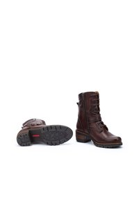 Brown leather ankle boots with a side zipper, laces, textured sole, and a stacked heel. Features decorative stitching and a rugged design.