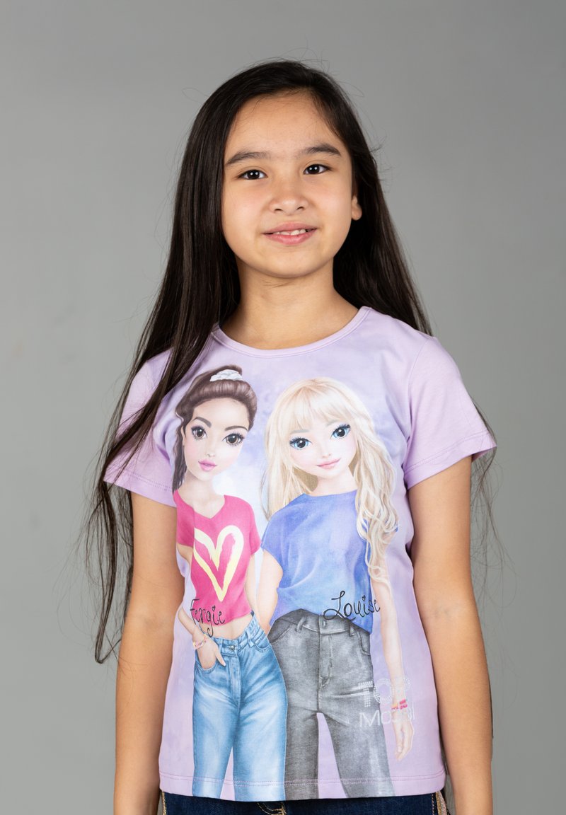 T-shirt a maniche corte di colore lilla con ragazze dei cartoni animati e nomi stampati, dettagli di abbigliamento blu e rossi, e una texture morbida e liscia.