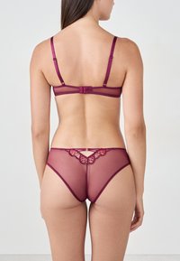 Set di lingerie in pizzo mauve con reggiseno trasparente a schiena scoperta e spalline regolabili, abbinato a perizoma con dettaglio in pizzo scallop e apertura a chiave.
