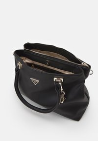 Sac Guess noir avec deux compartiments, accents dorés, logo avant, doublure intérieure beige et poignées arrondies sur un fond blanc.