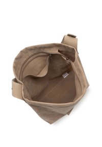 Sac fourre-tout en daim beige avec un intérieur spacieux, comprenant deux poches zippées et une seule bandoulière avec un détail de fermeture à pression.