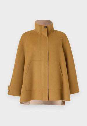 Ein senfgelber Wollmantel mit hohem Kragen, zwei Fronttaschen und einer lockeren A-Linien-Silhouette. Er verfügt über ein beiges Futter und einen Knopfverschluss.